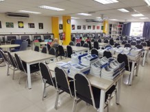 The library with rows of desks carrying new computers, beside shelving and study seating