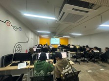 A second computer lab in use, with a wall mural and a projector screen at the front