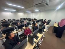 Students working at rows of new desktop computers in a refurbished computer lab