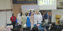 Students performing on stage at an English drama competition in a hall, in costume