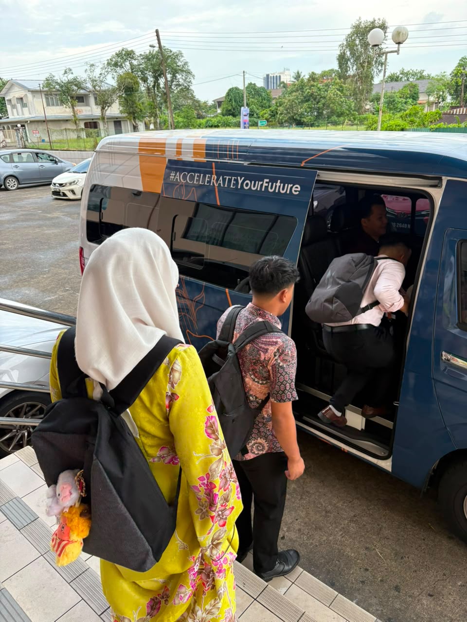 Students boarding the UNITAR shuttle van, marked #AccelerateYourFuture