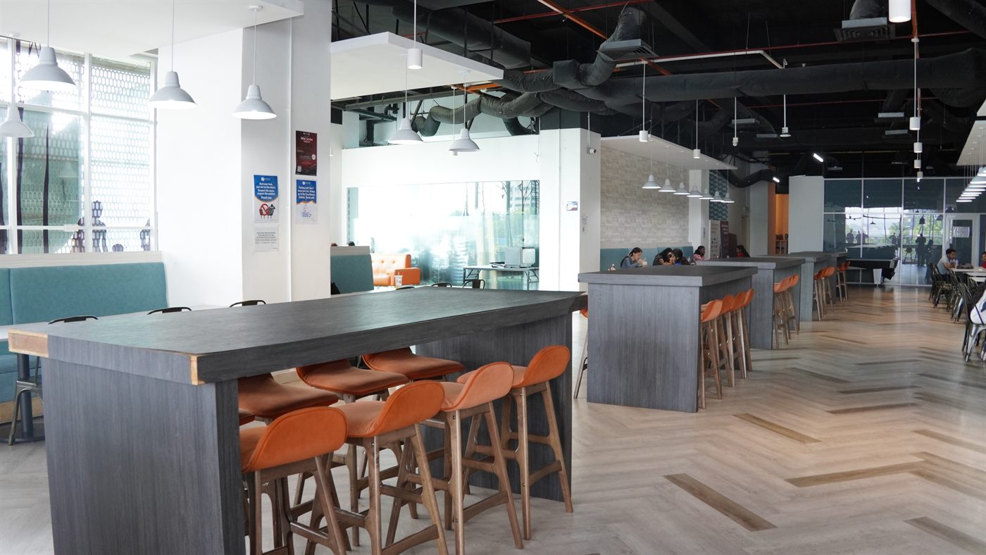 High tables with orange bar stools and booth seating in the café